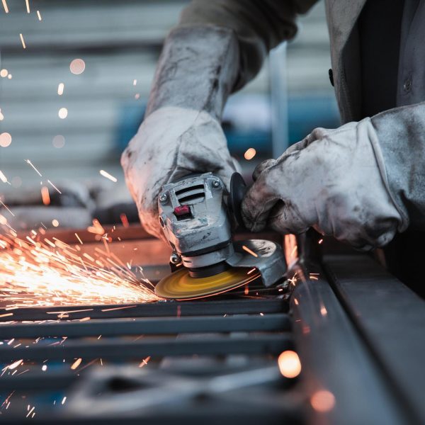 Ein Arbeiter schleift Metall und erzeugt dabei Funken.